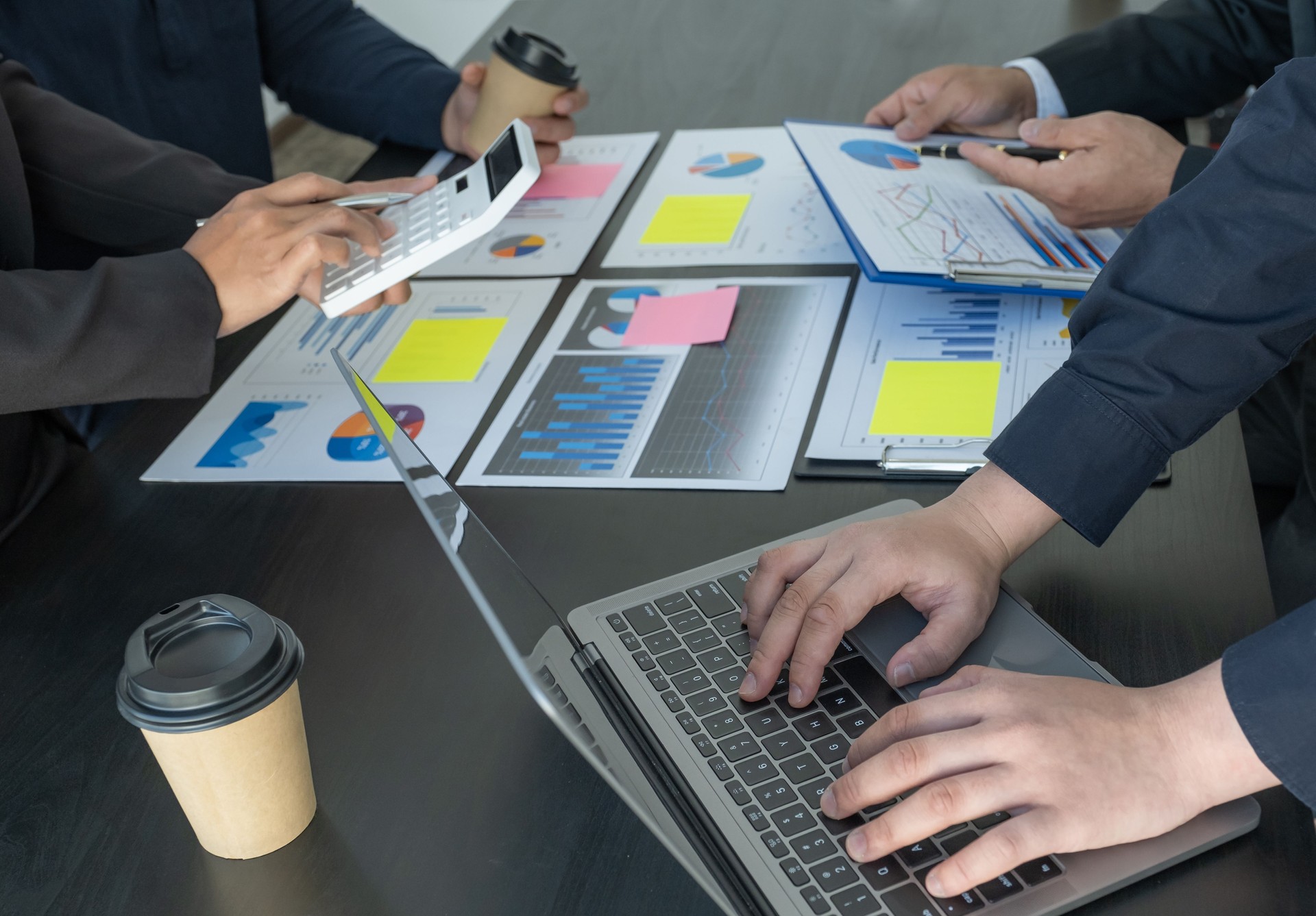 utiliser à la main un ordinateur portable, des femmes d’affaires et des hommes d’affaires se réunir pour planifier des stratégies visant à augmenter les revenus des entreprises. Avoir une analyse graphique de finance de remue-méninges et de discut